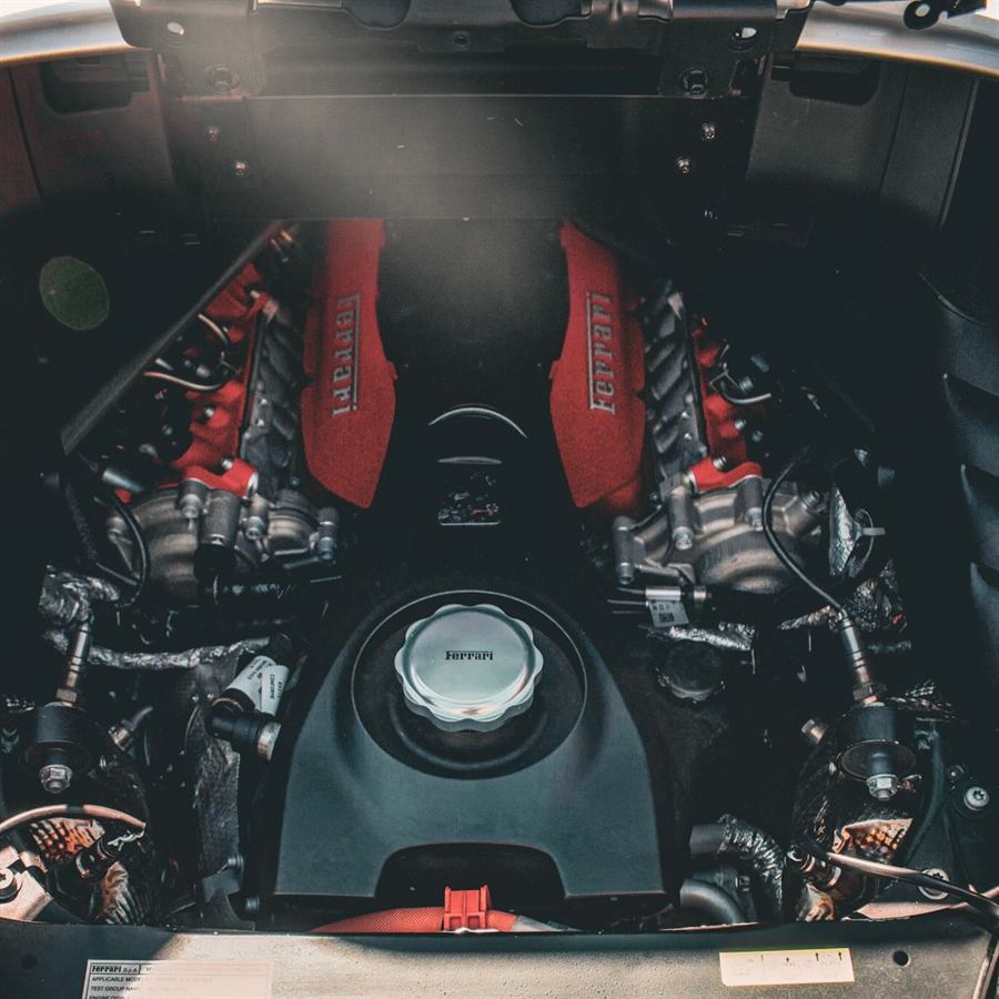 Detailed Ferrari V8 engine bay with red cam covers
