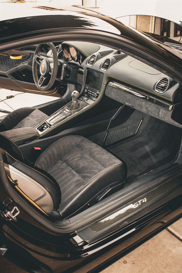 Alcantara bucket seats and yellow stitching inside a Porsche 718 GT4