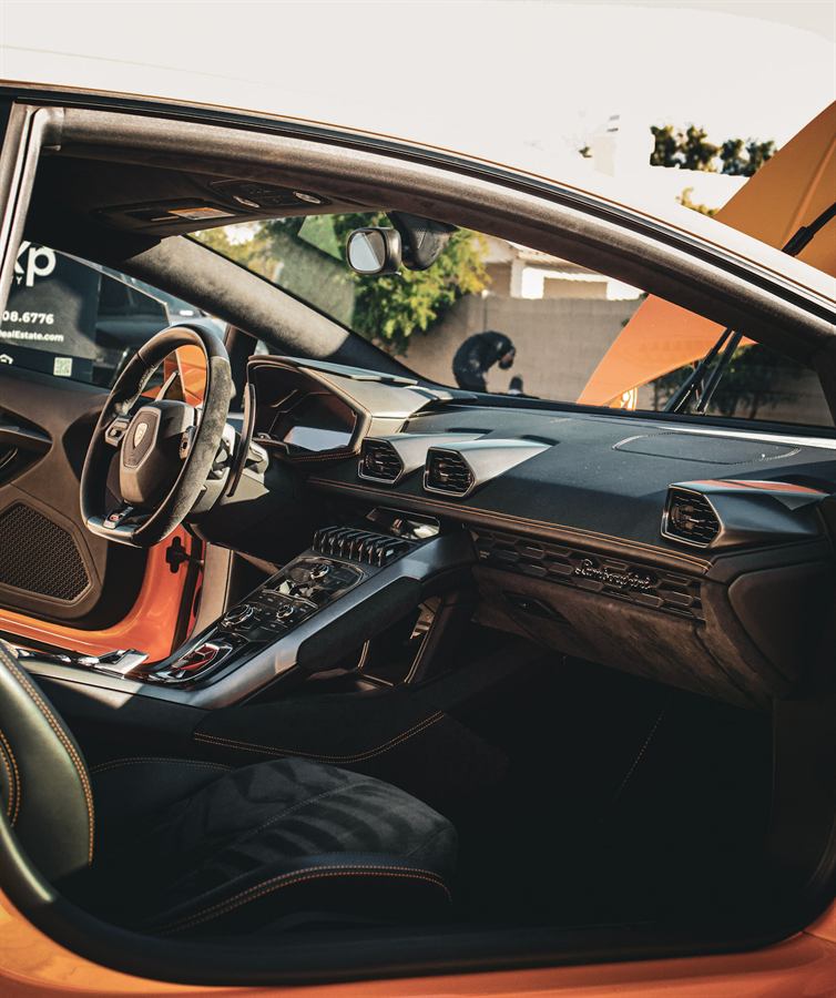 Black leather cockpit of a Lamborghini Huracán with orange accents