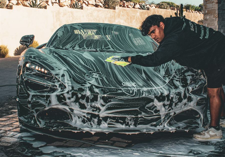 Sachin hand-washing a foamed McLaren 720S with a wash mitt